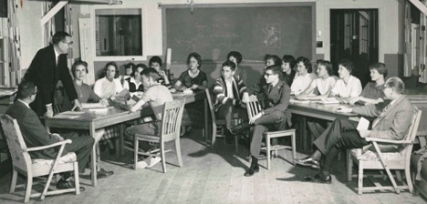 black and white photo of students sitting in a classroom and listening to a professor